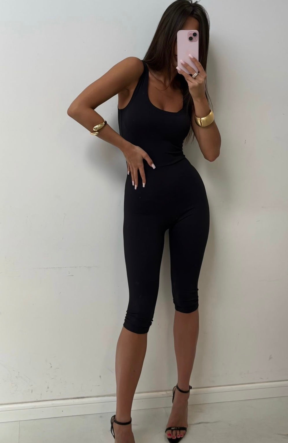 Liv black capri jumpsuit styled with black heels, full front view