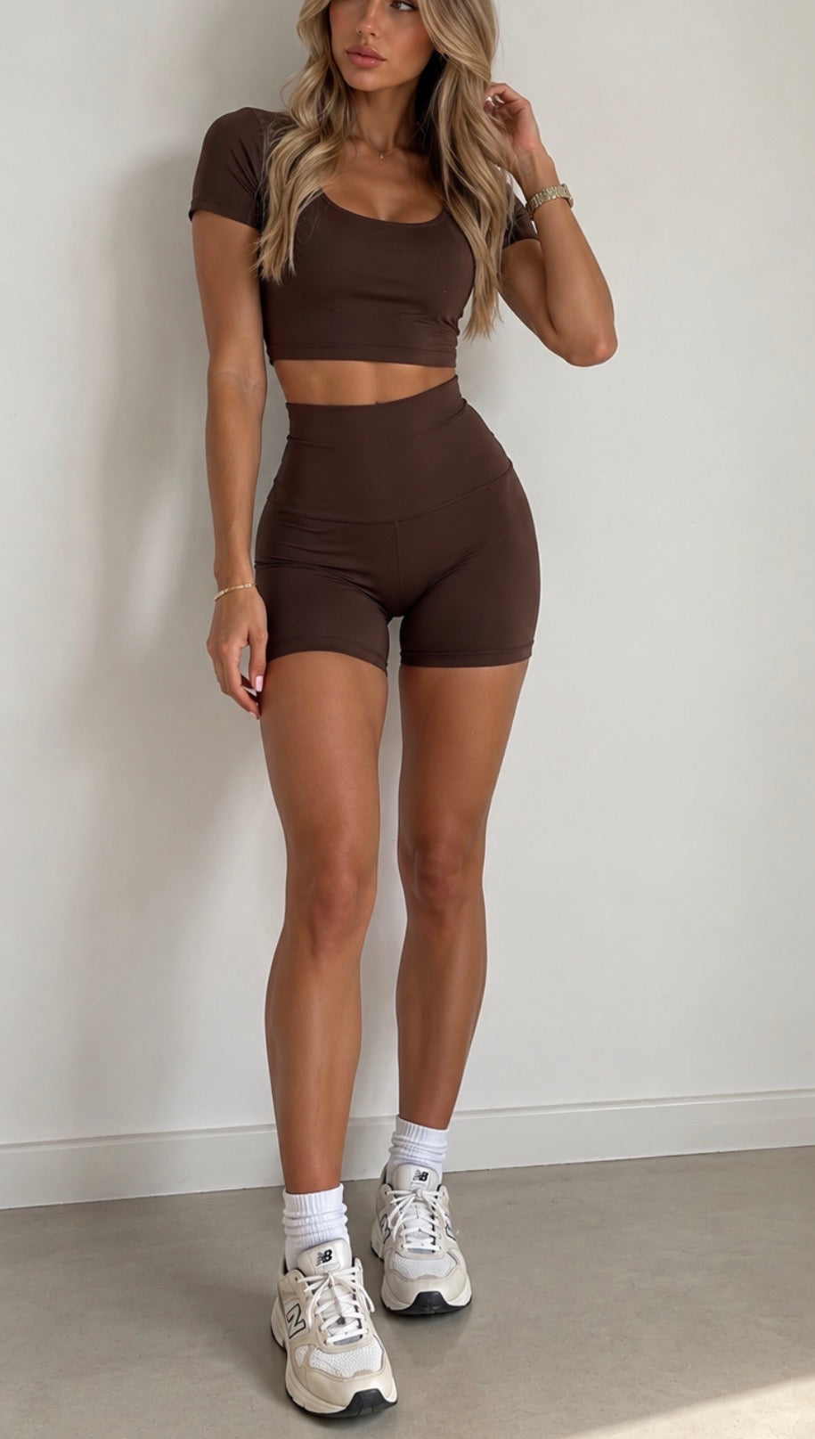 Maya chocolate high-waisted cycling shorts styled with a matching crop top and trainers