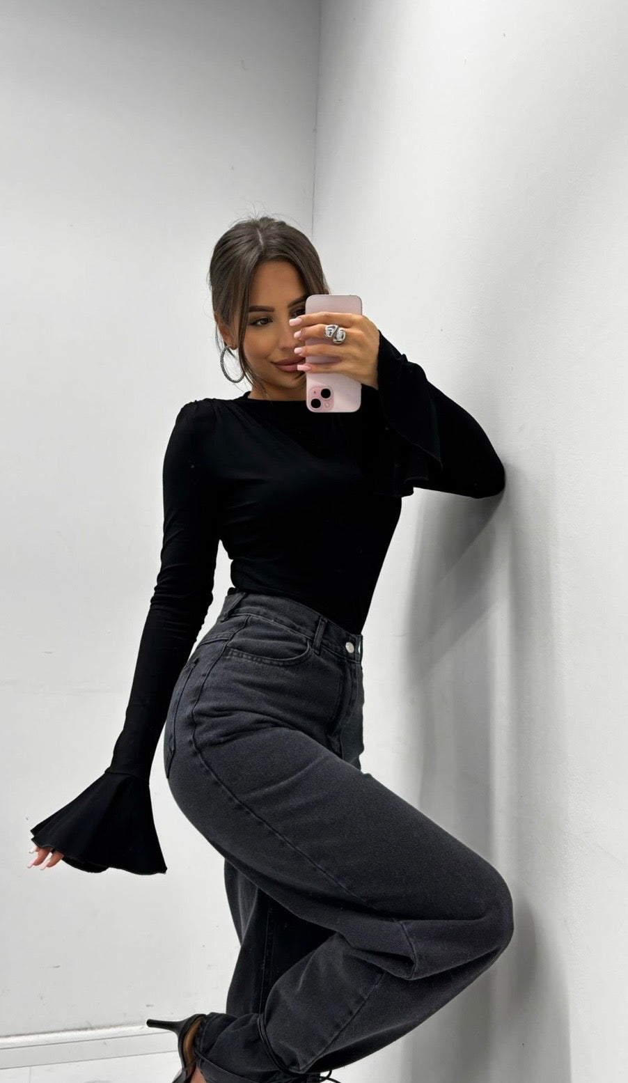 Veronica black flare sleeve top styled with washed-black wide-leg jeans